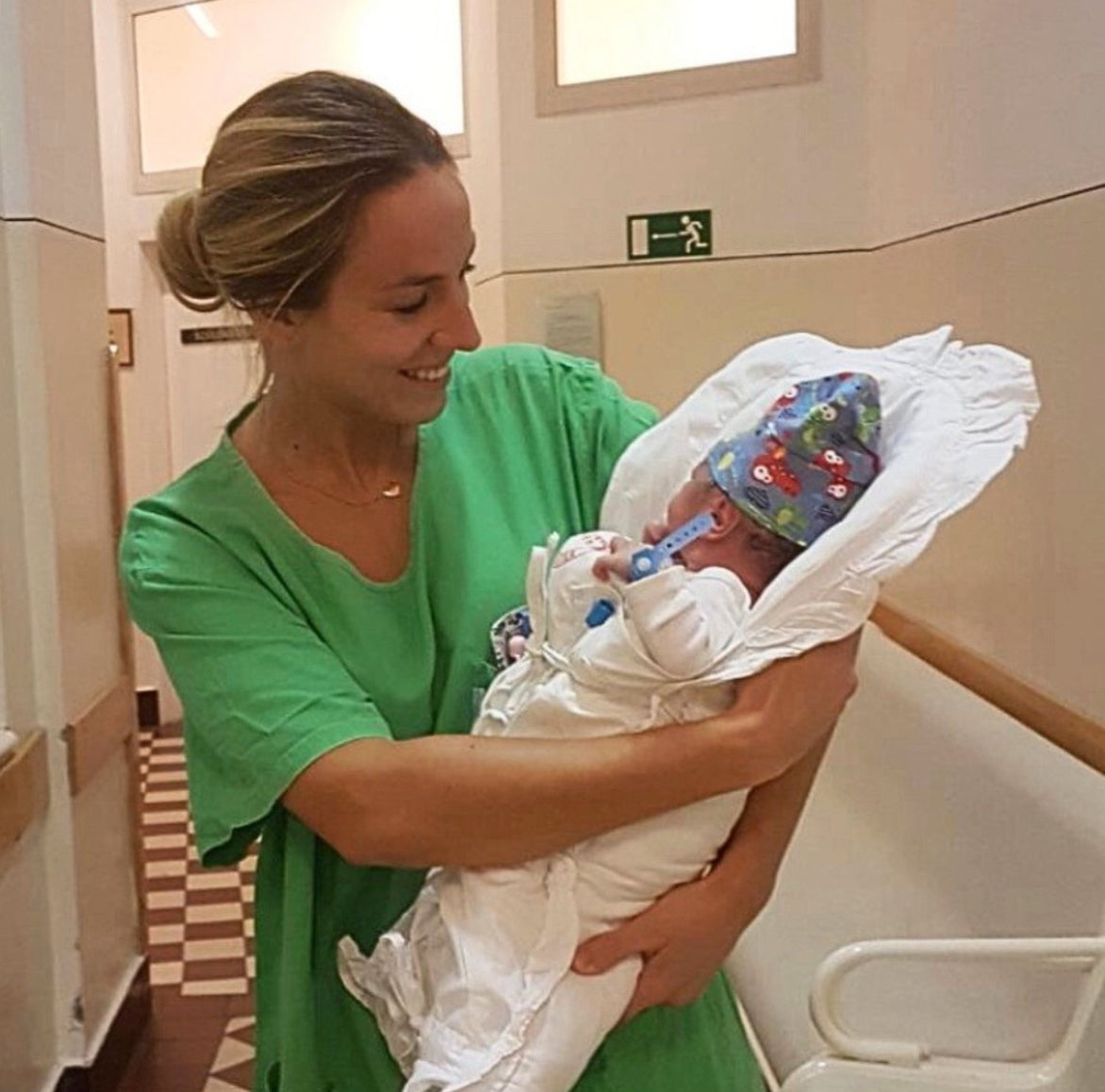 Laura Serra, matrona, sosteniendo a un bebé recién nacido